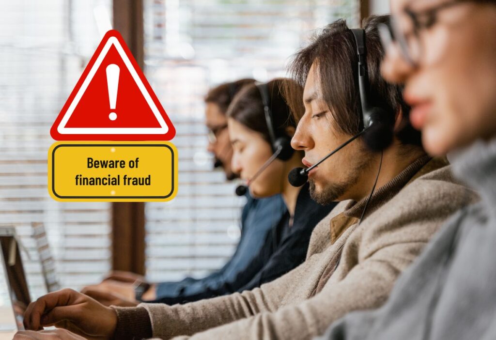 A call centre with a warning sign about financial fraud, highlighting vigilance against scam calls.