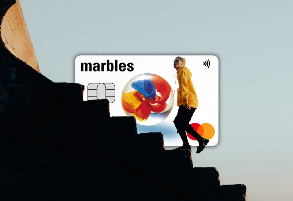 Marbles Credit Card featured with a person climbing stairs, representing progress and upward financial mobility.