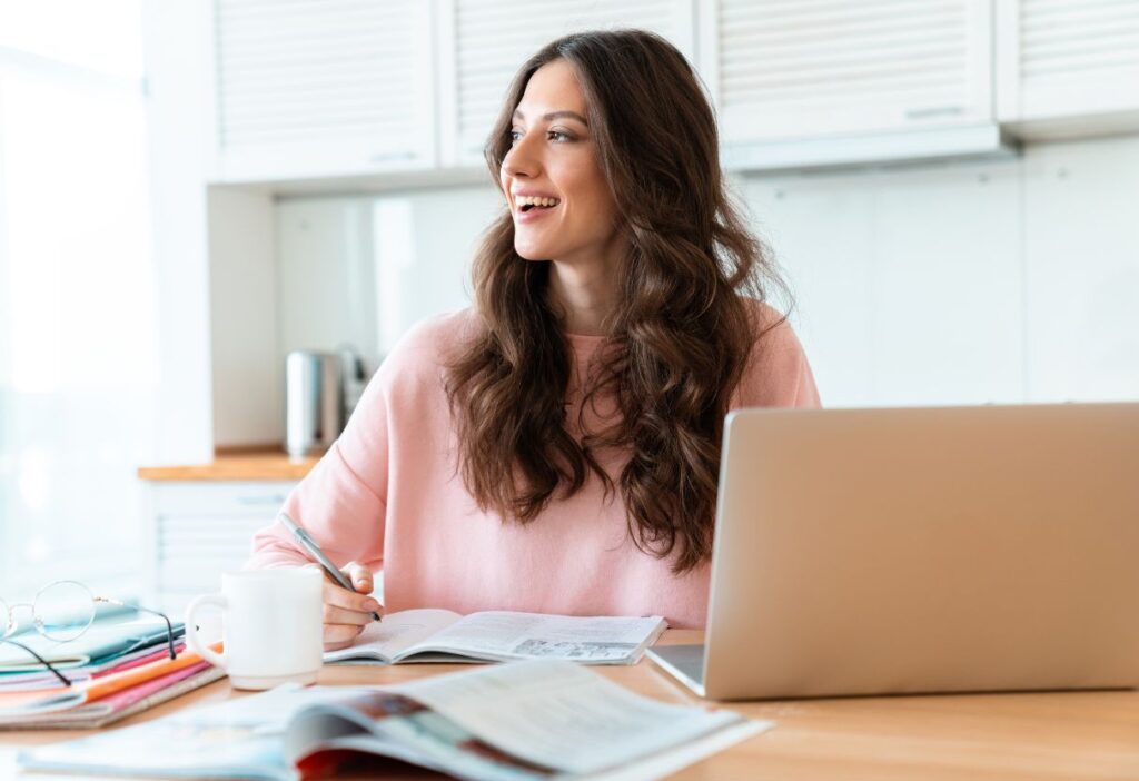 Young woman smiling while studying financial materials, representing learning about tax and savings.