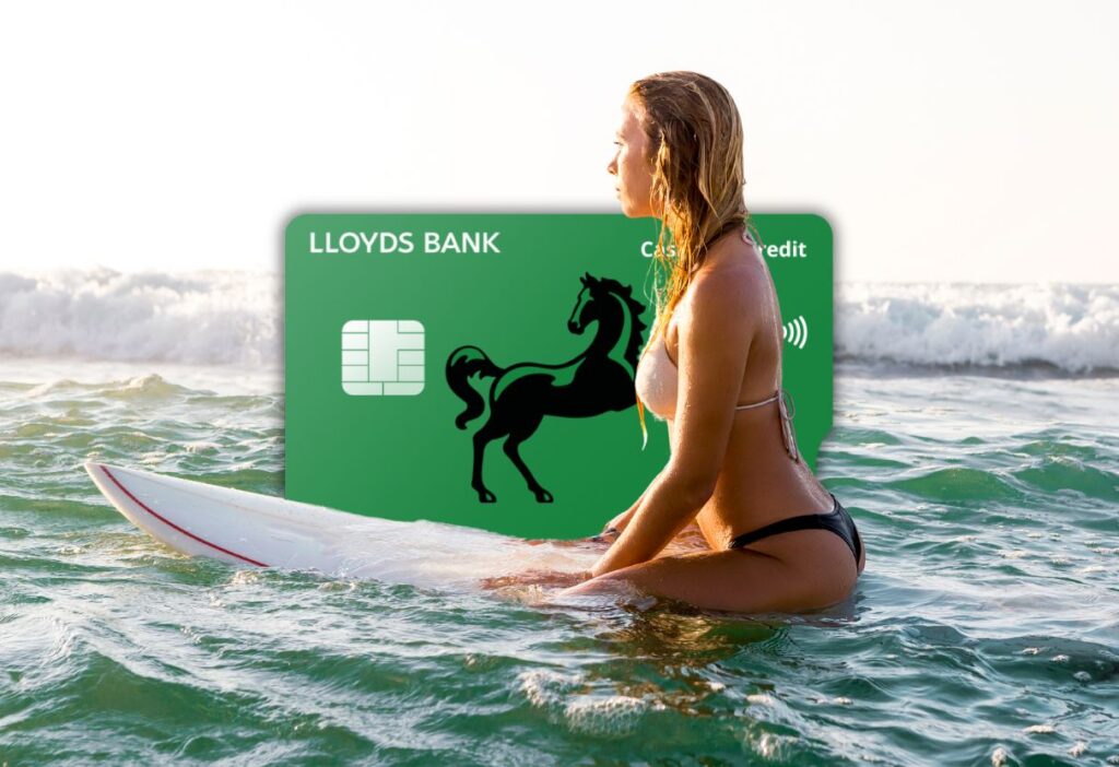 Surfer sitting on a surfboard in calm waters next to the Lloyds Bank Cashback Credit Card, highlighting its sleek green design with the black horse logo and Mastercard branding